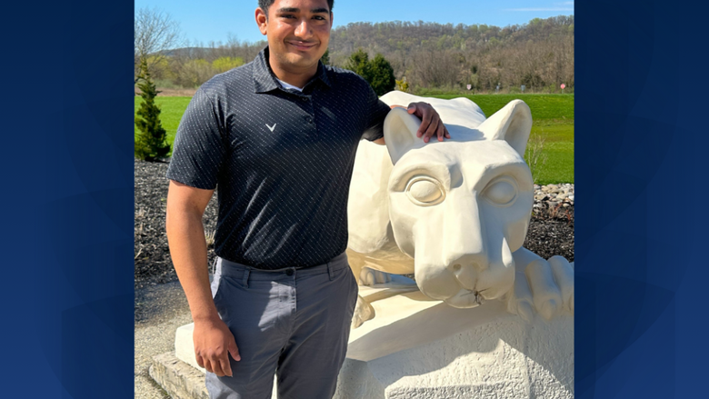 a male student standing in front of the lion shrine 